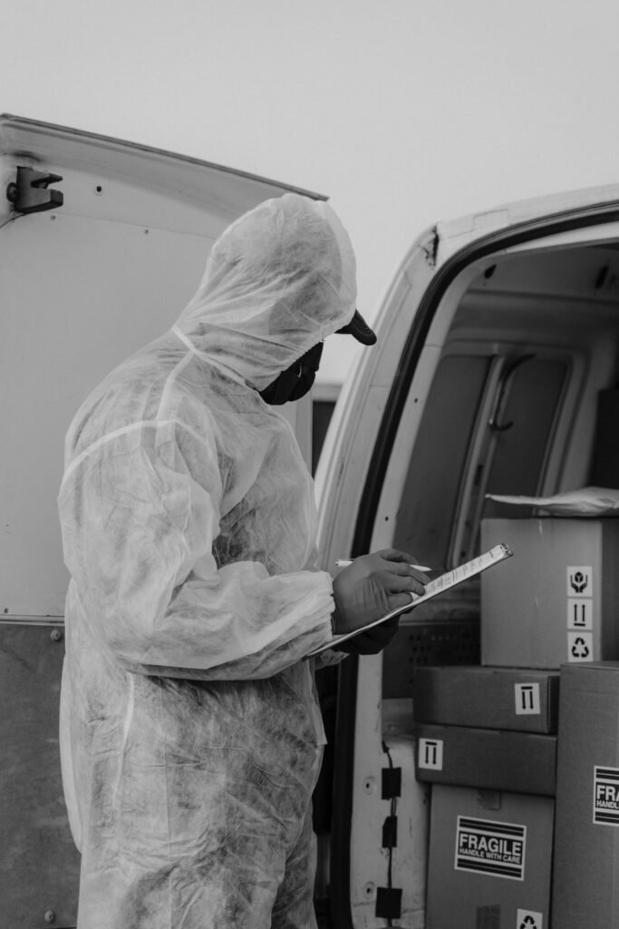 Home A courier in protective gear checking packages in a delivery van. Logistics and safety.