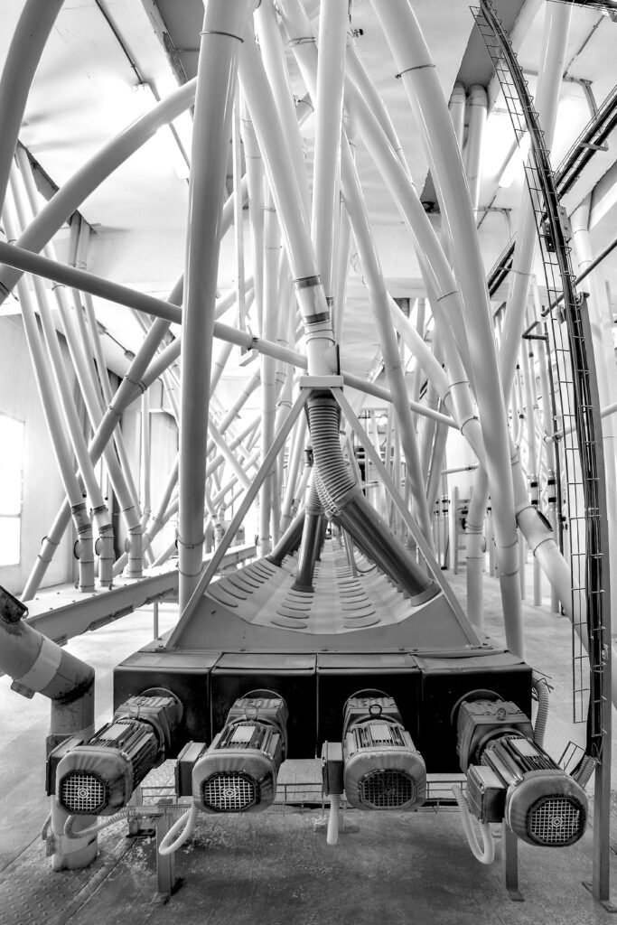 Black and white image of intricate pipe networks in an industrial facility.
